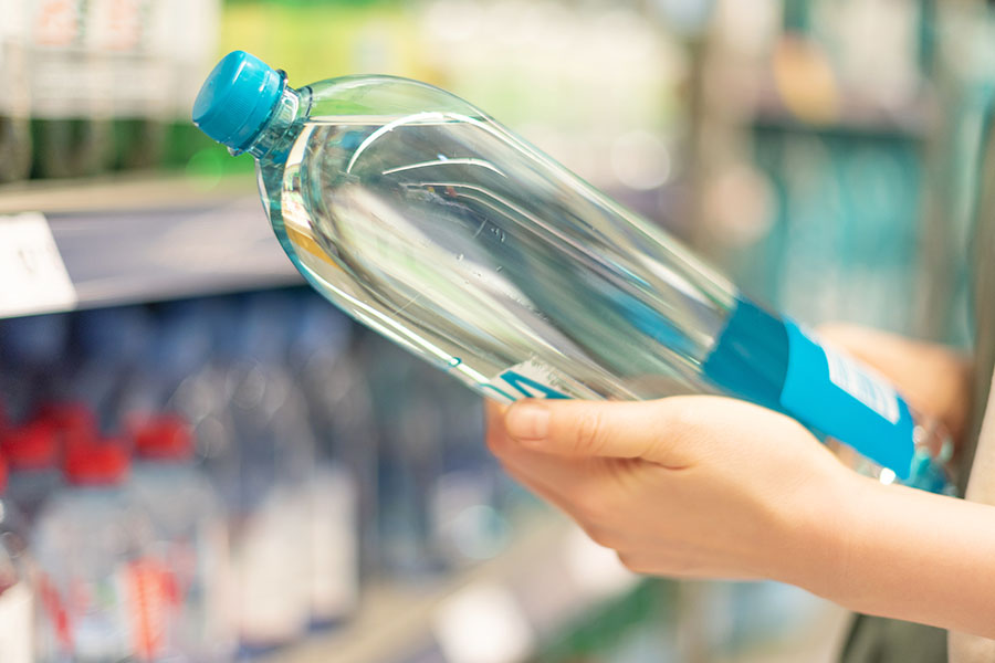 Kundin mit Wasserflasche im Supermarkt Kundin mit Wasserflasche im Supermarkt